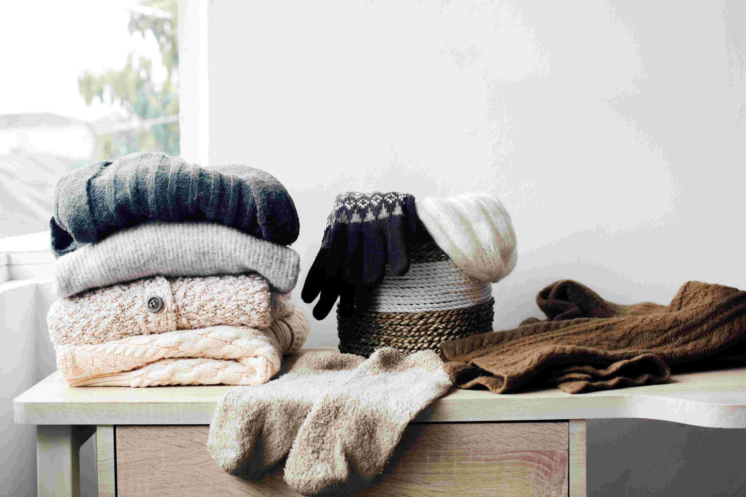 warm clothes folded on top of a dresser
